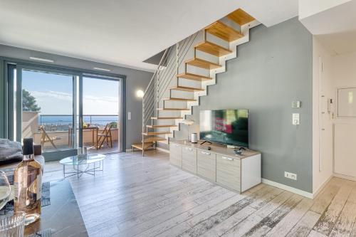 - un salon avec un escalier, une télévision et un canapé dans l'établissement Les Terrasses De Roquebrune - Happy Rentals, à Roquebrune-Cap-Martin