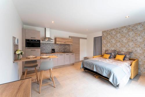 une chambre avec un grand lit et une cuisine dans l'établissement Studio Marquet, à Beaucaire