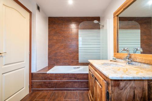 a bathroom with a bath tub and a sink at Casa Alegria in Pòrtol