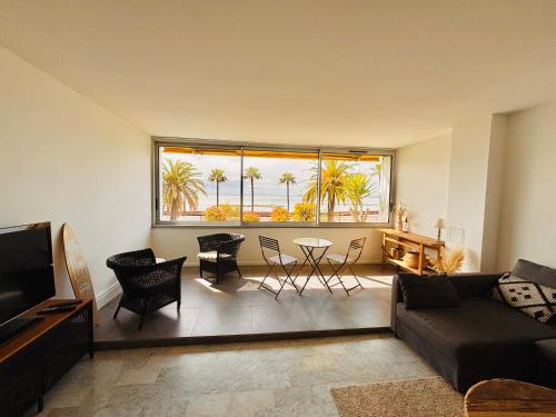 a living room with a couch and a table at Plage Landsberg - Saint-Laurent-du-Var in Saint-Laurent-du-Var