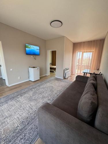 a living room with a couch and a flat screen tv at Алые Паруса in Cholpon-Ata