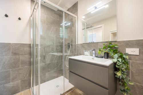 ein Badezimmer mit Dusche, Waschbecken und Spiegel in der Unterkunft Wave Island H2 in Lido di Jesolo