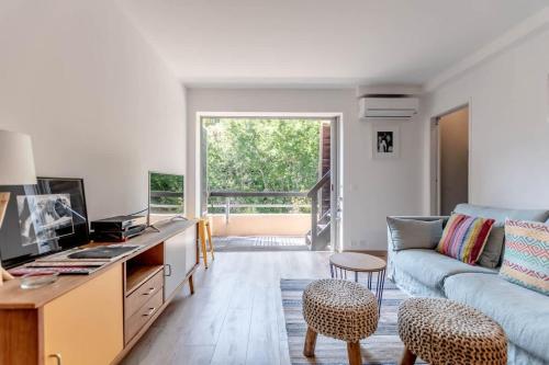 un salon avec un canapé et une table dans l'établissement Le Bailly l Beachside & Rooftop l Shellter Rentals, à Saint-Tropez