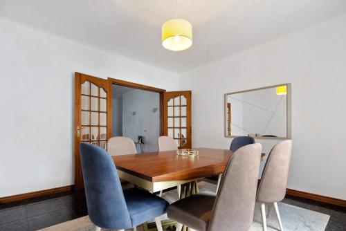 a dining room with a wooden table and chairs at Pascoal House in Ribeira Grande
