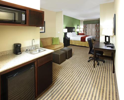 a hotel room with a kitchen and a bedroom at Holiday Inn Express & Suites Maumelle by IHG in Maumelle