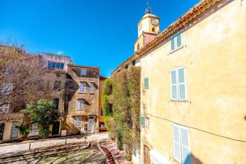 Une allée dans une vieille ville avec une tour de l'horloge dans l'établissement L'Ormeau l Historic St-Tropez l Shellter Rentals, à Saint-Tropez