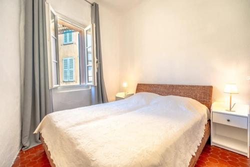 une chambre avec un lit blanc et une fenêtre dans l'établissement L'Ormeau l Historic St-Tropez l Shellter Rentals, à Saint-Tropez