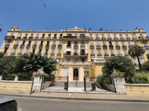 un grand bâtiment jaune sur le côté d'une rue dans l'établissement Les îles d'or, à Hyères