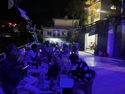 a group of people sitting in chairs at night at Urban Loft Hostel in Rishīkesh