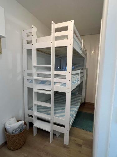 Ce lit superposé blanc se trouve dans un dortoir. dans l'établissement Studio cosy au porte de l ocean, à Biscarrosse