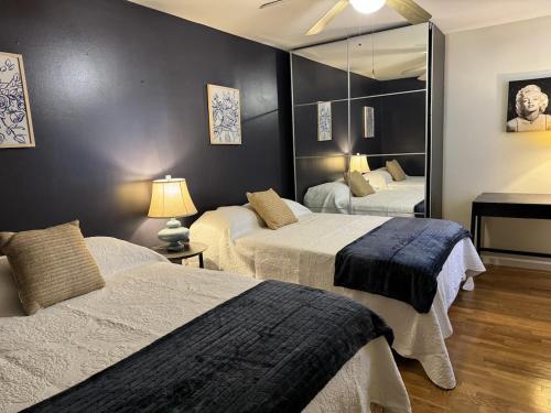a bedroom with two beds and a mirror at Park View Corp Two Units - 15 Mins to NYC in Union City