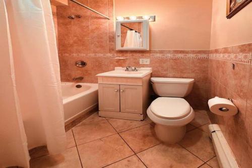 a bathroom with a toilet and a sink and a tub at Park View Corp Two Units - 15 Mins to NYC in Union City