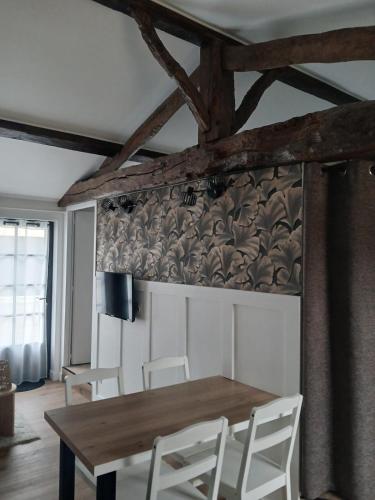 a dining room with a wooden table and white chairs at Gîte Héloïse in Le Pallet