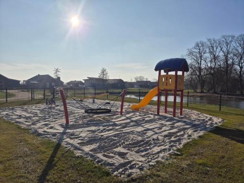 a playground with a slide in a park at Riesiges Ferienhaus mit 4 SZ an der Nordsee! Sauna in Sehestedt