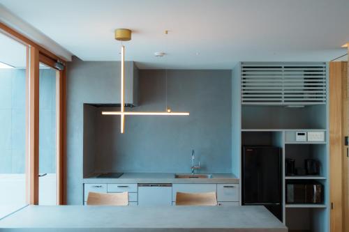 a kitchen with a sink and a counter with chairs at Villa NIGIN in Miyazu