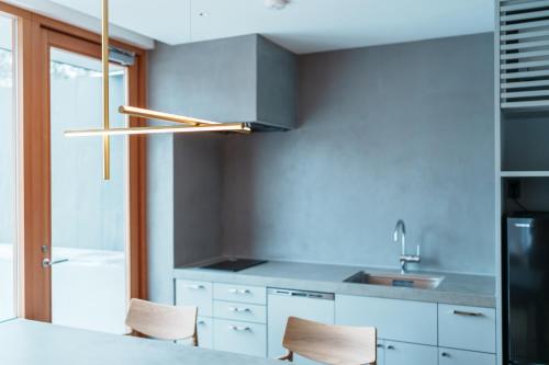 a kitchen with white cabinets and a stainless steel hood at Villa NIGIN in Miyazu