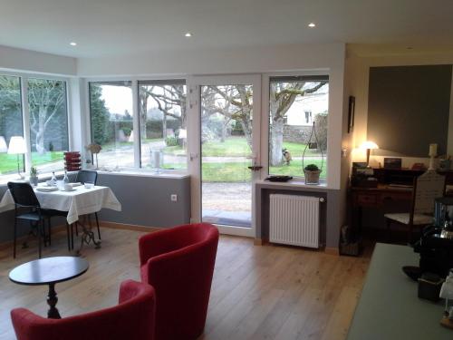 a dining room with a table and chairs and windows at Résidence CoatArmor in Tonquédec