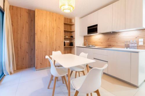 - une cuisine avec une table blanche et des chaises blanches dans l'établissement Studio Résistance l Central l Shellter Rentals, à Saint-Tropez