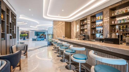 a bar in a restaurant with blue stools at Radisson Hotel Istanbul Merter in Istanbul