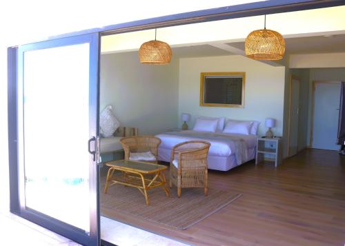 a bedroom with a bed and a table and chairs at Secret Sunrise in Jeffreys Bay