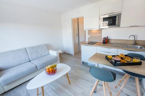 - un salon avec un canapé et une table avec un plateau de fruits dans l'établissement Joli Studio proche Promenade des Anglais, à Nice