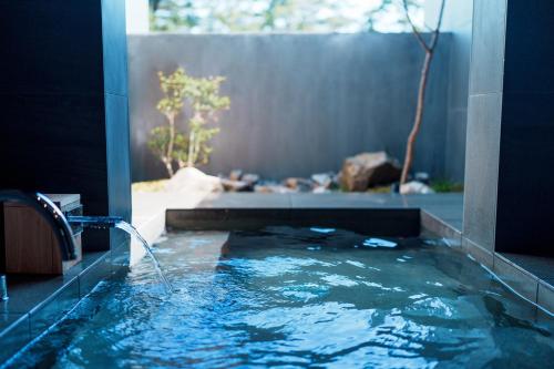 a bathroom with a tub with a water fountain at Villa NIGIN in Miyazu