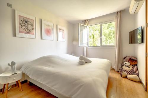 une chambre blanche avec un grand lit et une fenêtre dans l'établissement Floralies B l Bright & Parking l Shellter Rentals, à Saint-Tropez
