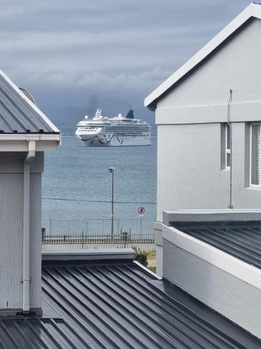 a cruise ship in the water with a house at Suite at Bay in Mossel Bay
