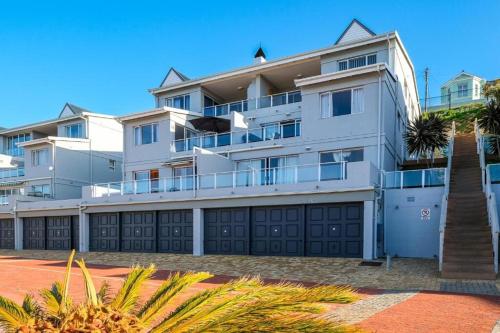 a large white apartment building with a garage at Suite at Bay in Mossel Bay
