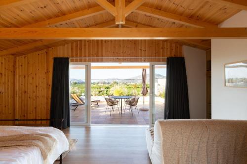 a bedroom with two beds and a patio with a table at Villa Plaka 16 - 'The Roof' - Drepano, Nafplio in Dhrepanon
