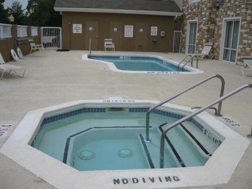 a pool with a hot tub in a yard at Holiday Inn Express Williamston by IHG in Williamston
