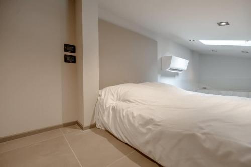 une chambre avec un lit blanc dans une pièce dans l'établissement Studio Blanqui l Design & Cozy l Shellter Rentals, à Saint-Tropez