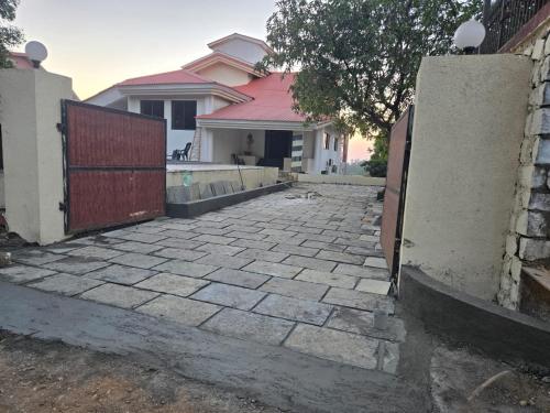 a driveway with a gate in front of a house at Mountain Breeze Villa in Khandala