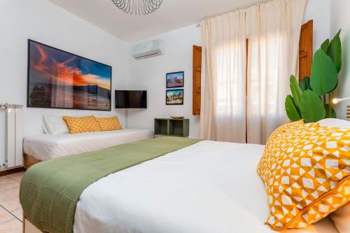 a hotel room with two beds and a tv at Home Centrum 2 in Giarre
