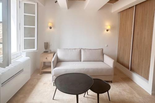 un salon avec un canapé et une table dans l'établissement Le Paon l Old Town & AC l Shellter Rentals, à Saint-Tropez