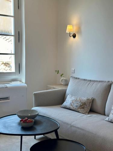 un salon avec un canapé et une table dans l'établissement Le Paon l Old Town & AC l Shellter Rentals, à Saint-Tropez