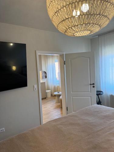 a bedroom with a bed and a large chandelier at Quedlinburg Marktplatz-Suites in Quedlinburg