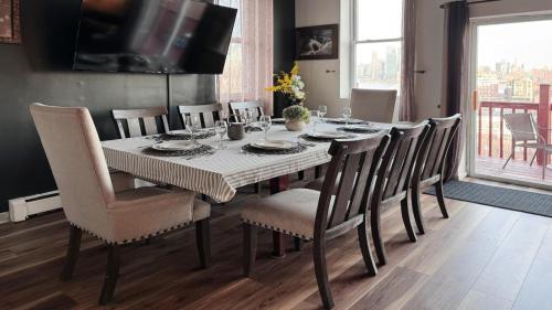 a dining room table with chairs and a television at Mega See NY Now - Midtown - Apt 1 & 2 Combo in Union City