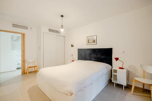 a bedroom with a white bed and a table and chairs at La Suite d'Oscar l New, Terrace l Shellter Rentals in Saint-Tropez