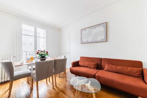 un salon avec un canapé et une table dans l'établissement Appartement 3 Pieces au Coeur du 19e - 4P, à Paris
