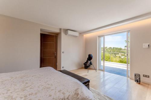 - une chambre avec un lit et une grande porte en verre dans l'établissement Magnificent villa, heated pool, air cond, sea view, à Sainte-Maxime