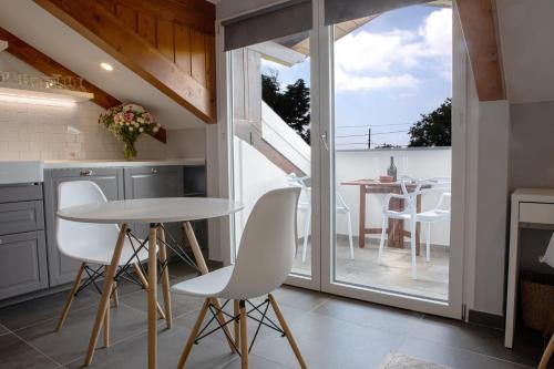 a kitchen with white chairs and a table at The Cliff Amalfi Coast - Apartment 1 in Pianillo