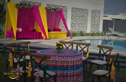 a table and chairs next to a swimming pool at Ritz Resort Lucknow- The Perfect Blend of Business and Leisure in Lucknow