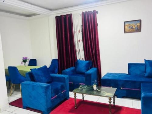 a living room with blue chairs and a table at Complexe A8CLOS in Douala