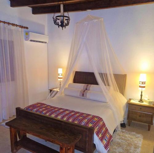 a bedroom with a bed with a mosquito net at HideAway Lasa in Lasa