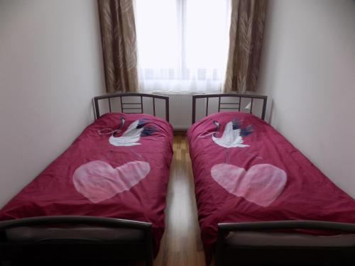 two beds with hearts painted on them in a room at Stan na dan Sunce in Lukavica
