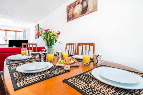 a dining room table with plates and glasses of orange juice at Elstree Luxury Hse Contractors, Family, Industrial Area Harry Porter in Hemel Hempstead