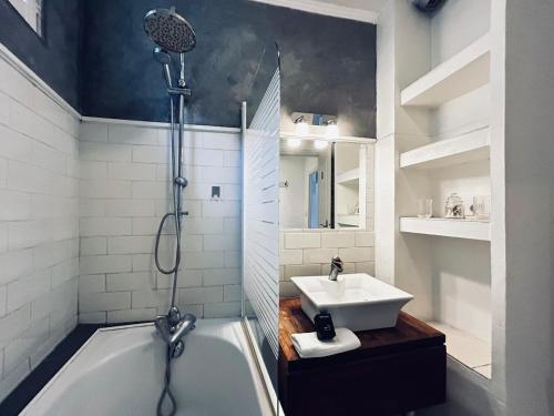 une salle de bain avec une baignoire et un lavabo dans l'établissement Une bulle en champagne T3 hyper centre avec balcon, à Reims