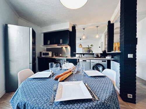 une cuisine avec une table et un chiffon bleu dans l'établissement Une bulle en champagne T3 hyper centre avec balcon, à Reims