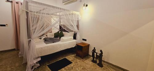 a bedroom with a bed with a canopy at Summer Heritage Villa in Unawatuna